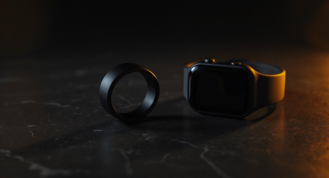 A smart ring and fitness watch on a dark slate surface