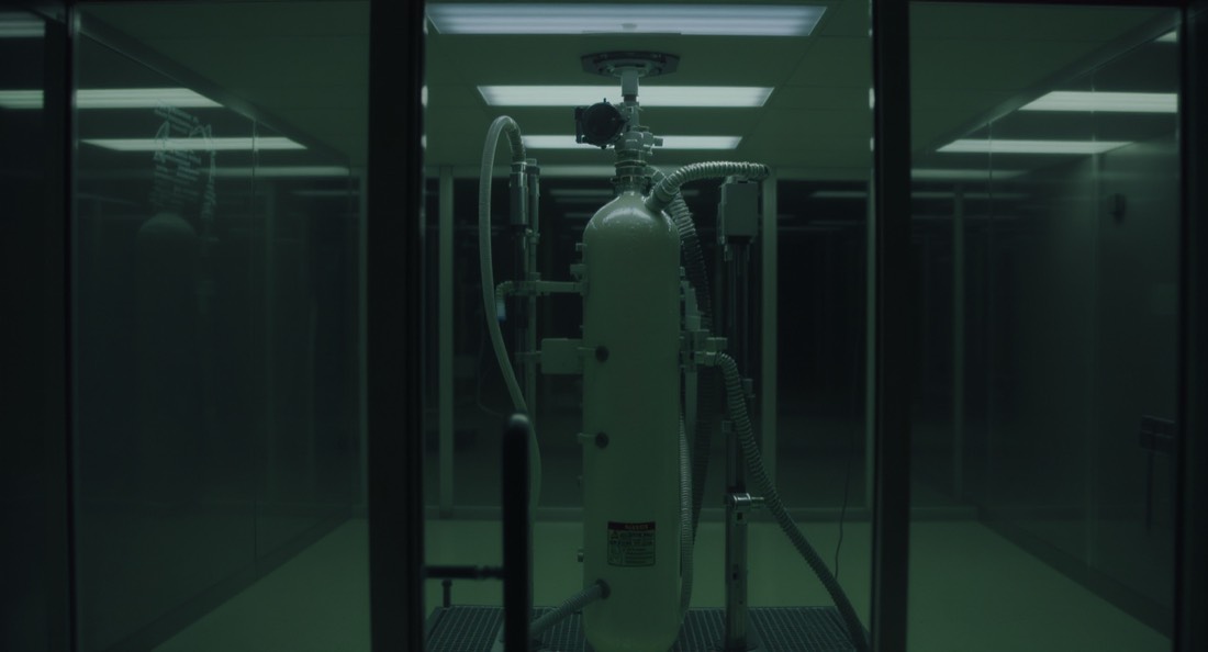 A clear-walled hyperbaric oxygen chamber in a clinical room, unoccupied