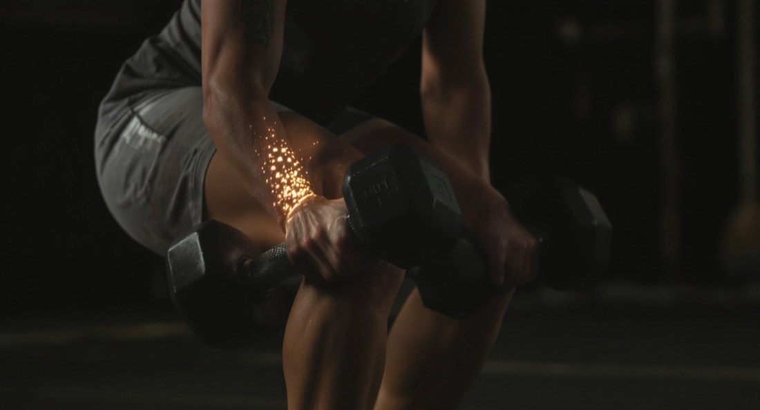 A woman in her fifties performing a rear-foot-elevated split squat with dumbbells