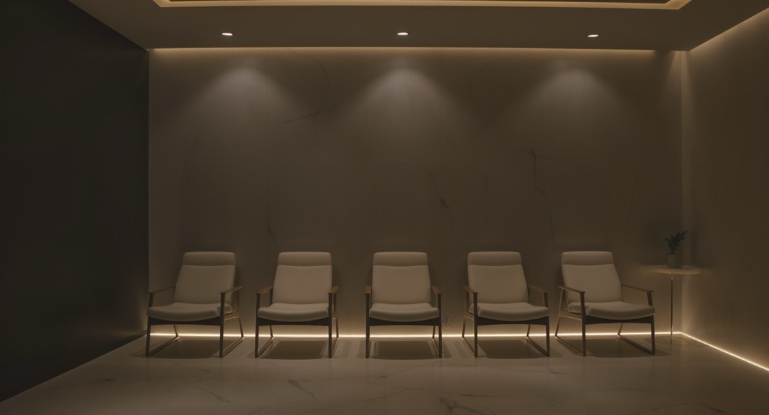 A modern longevity clinic waiting area with empty chairs and soft lighting